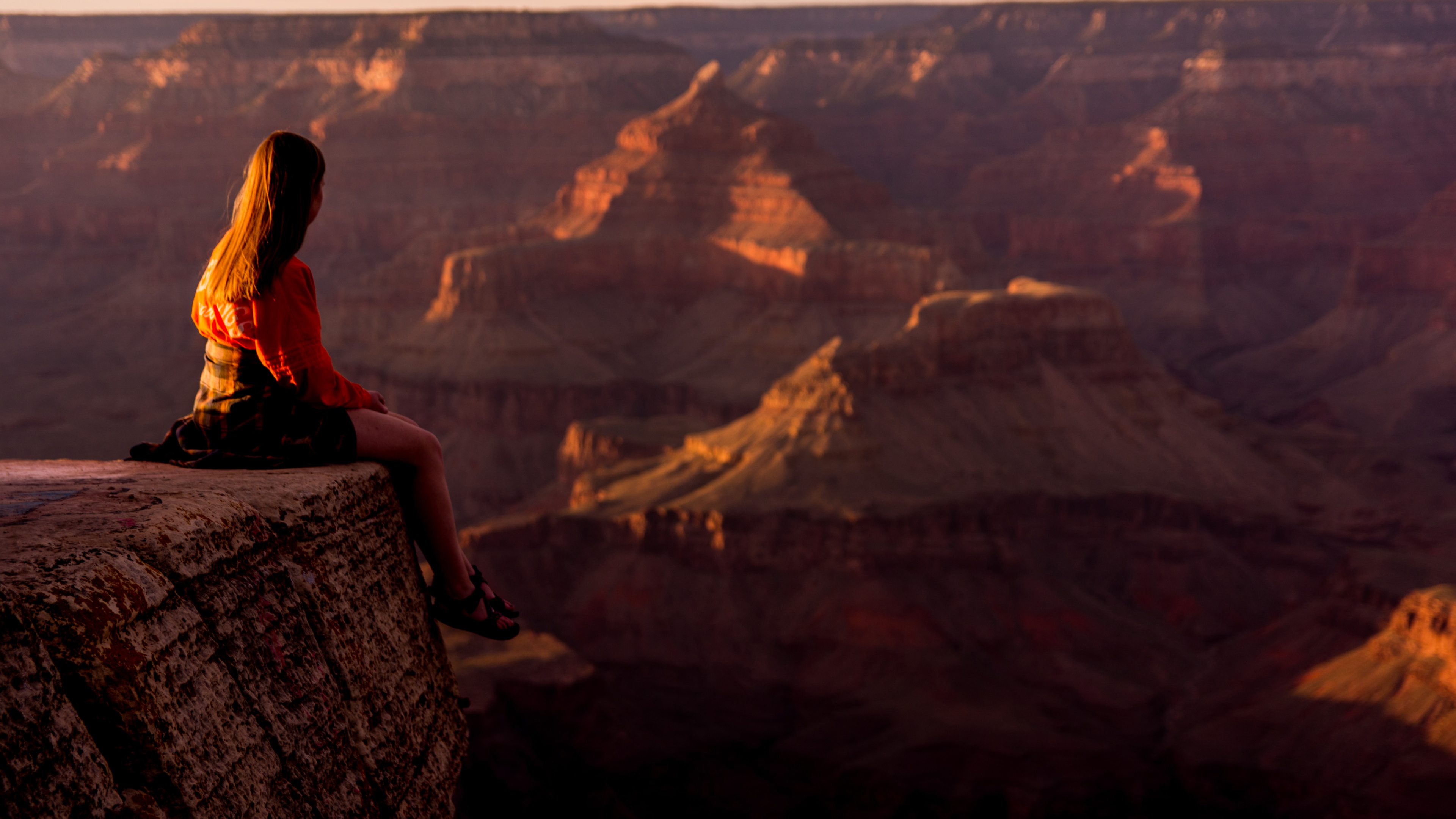 坐在<span style='color:red;'>大峡谷</span>悬崖边上的欧美美女和宏伟的峡谷风景高清壁纸