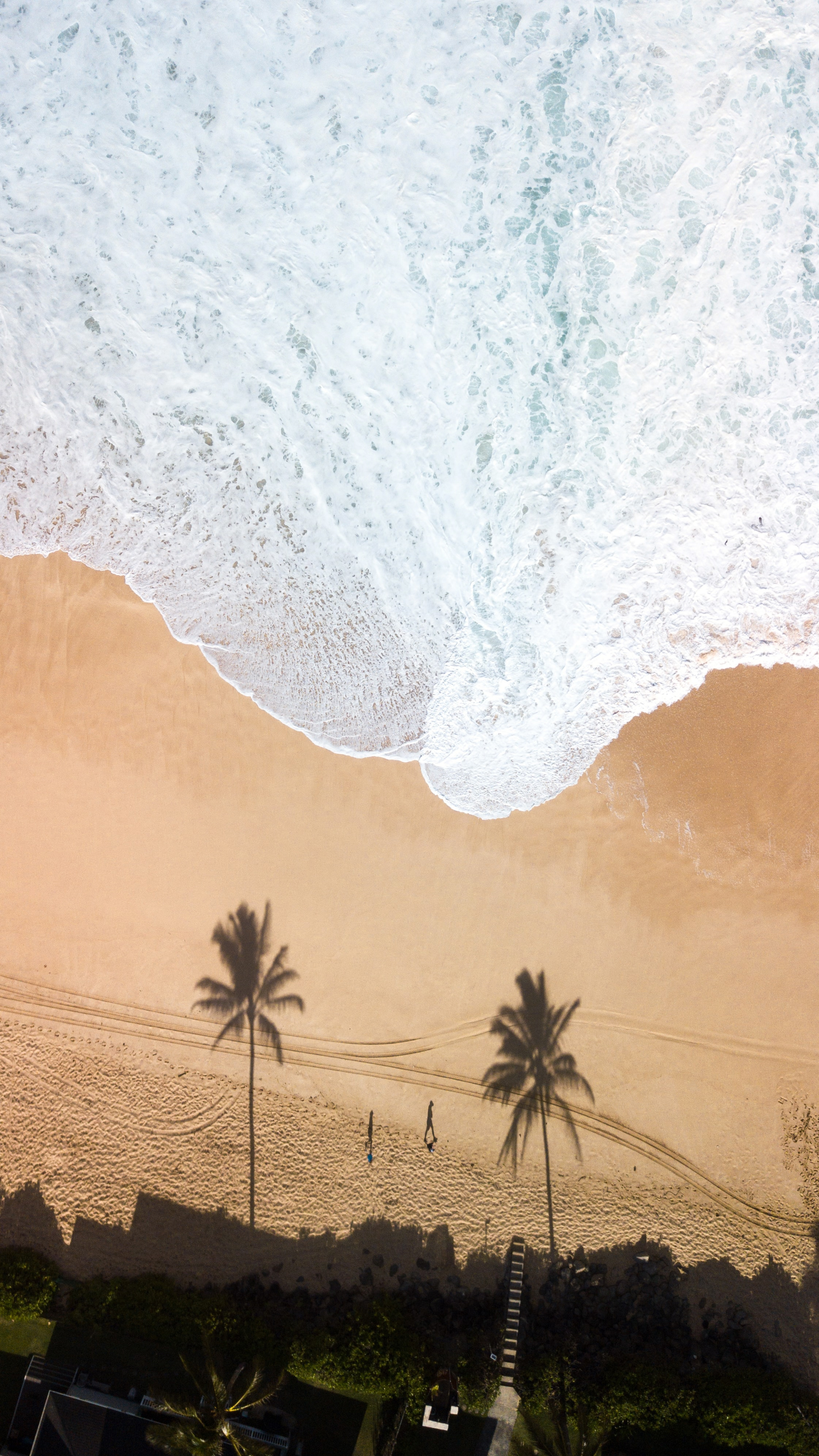 海上大浪冲刷着沙滩的高空风景手机壁纸下载