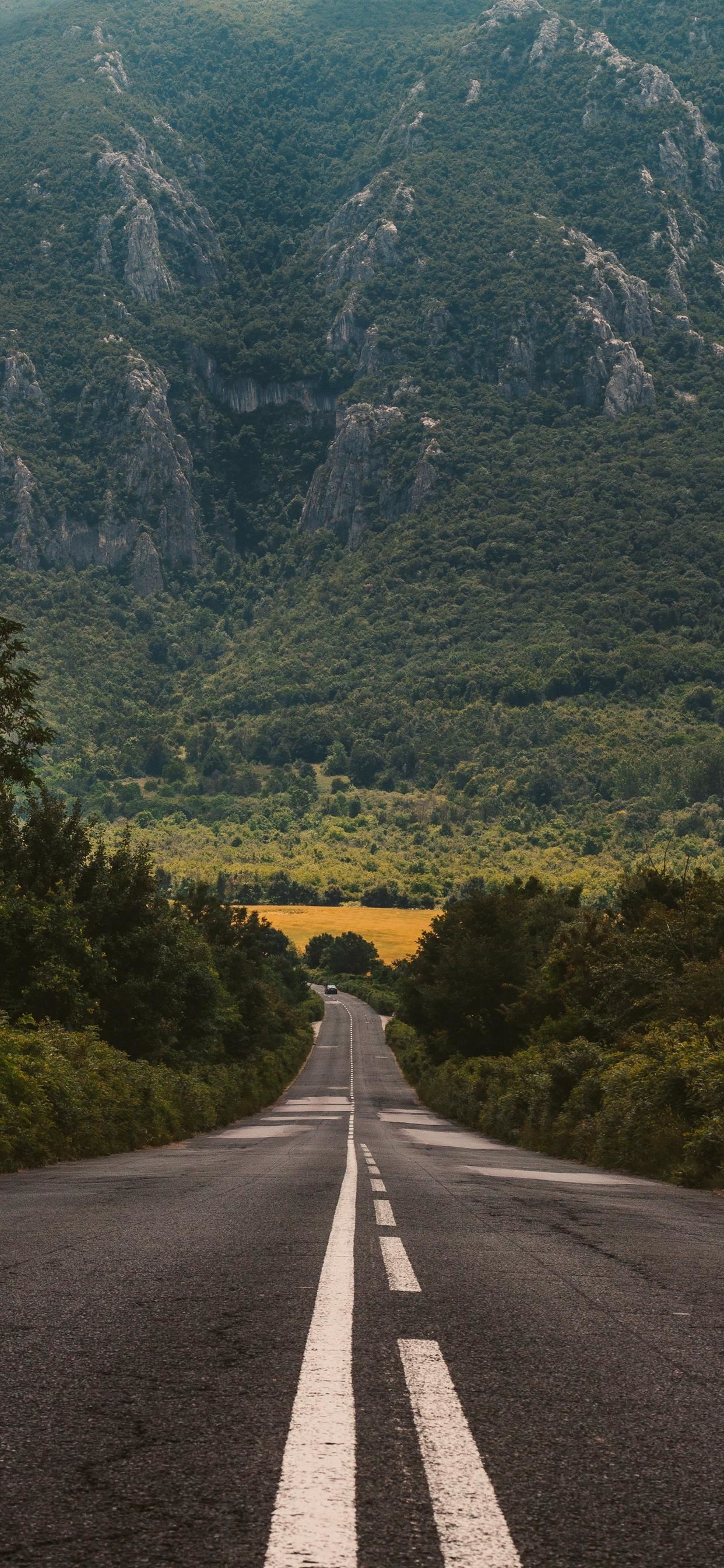 穿越大山山脉的下坡路段公路的唯美摄影手机壁纸