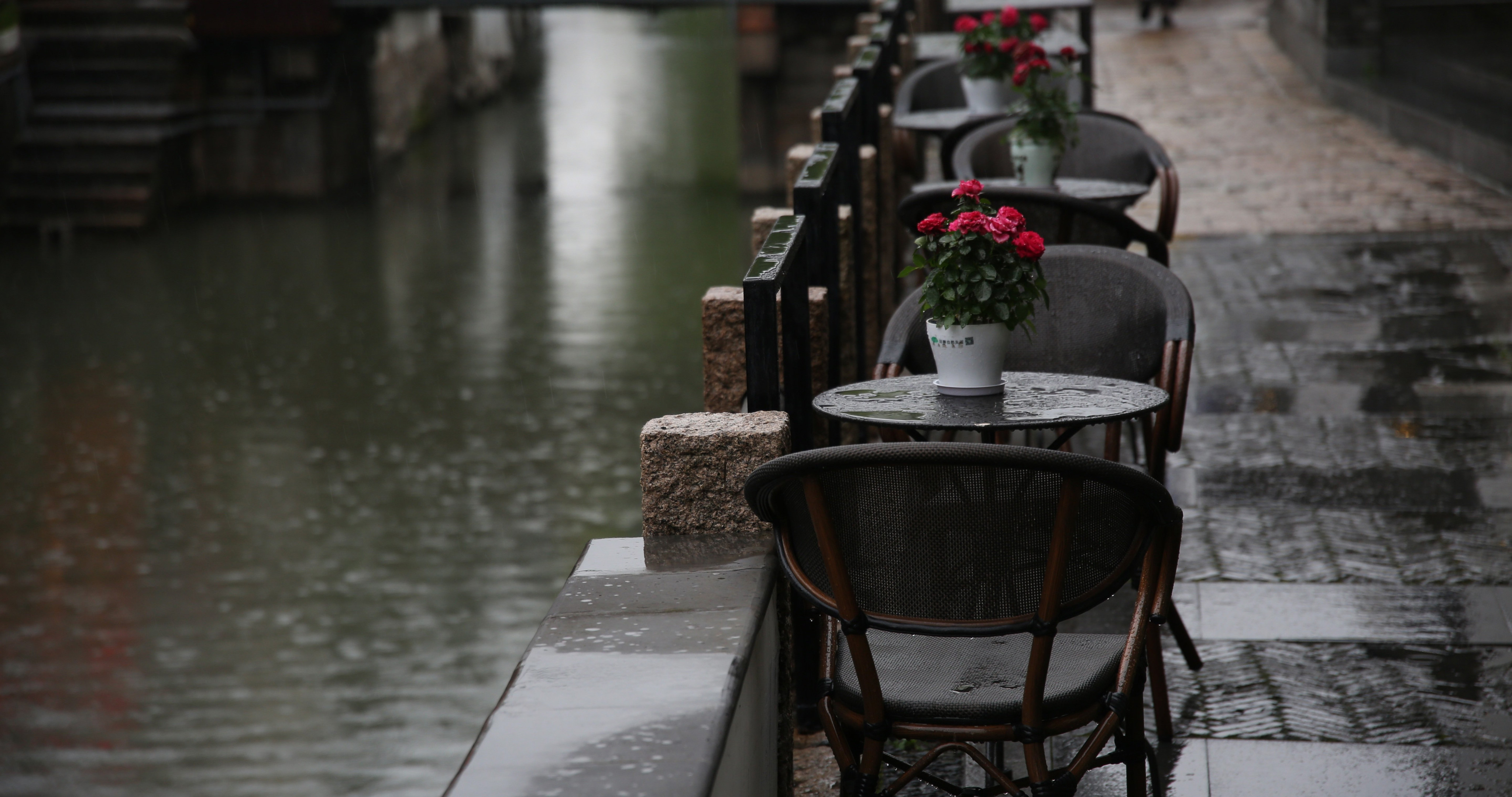 下雨的古镇，河边的古镇石头<span style='color:red;'>围栏</span>边的餐厅座椅唯美摄影电脑壁纸