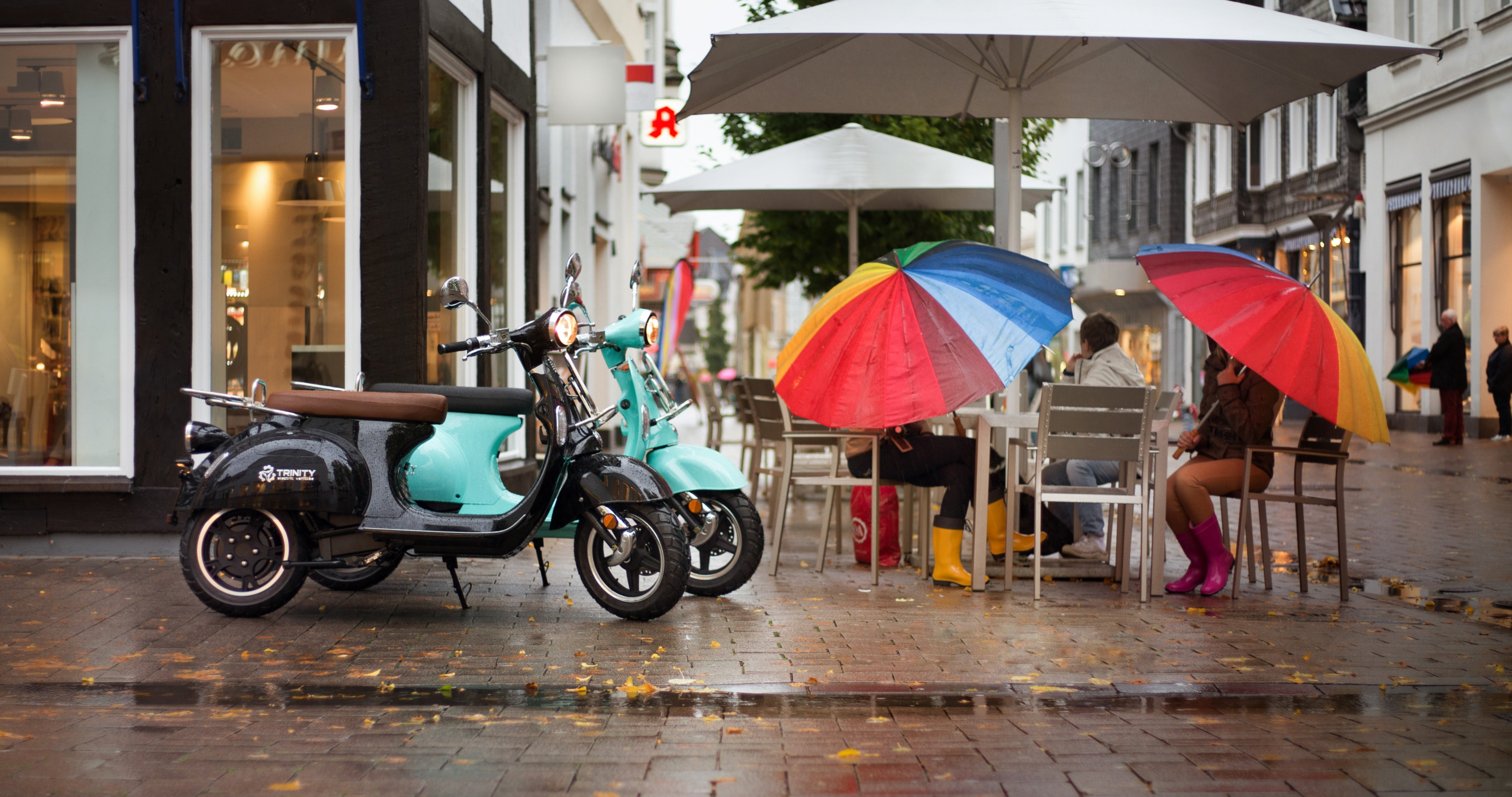 下雨的城市街头，在餐厅门前躲雨的路人场景桌面壁纸