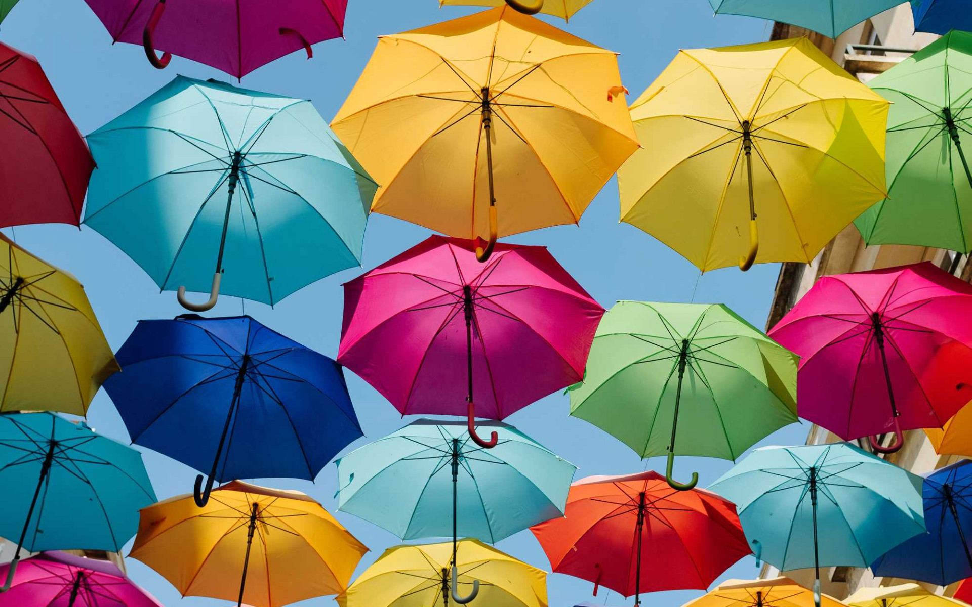 挂在街道上空的七彩雨伞的创意街景电脑壁纸