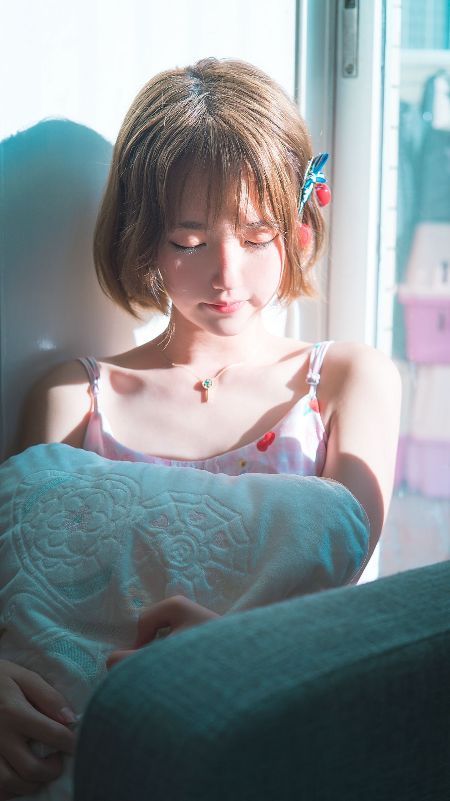 窗户前，阳光中，抱着枕头的短发漂亮美少女高清2K手机壁纸图片