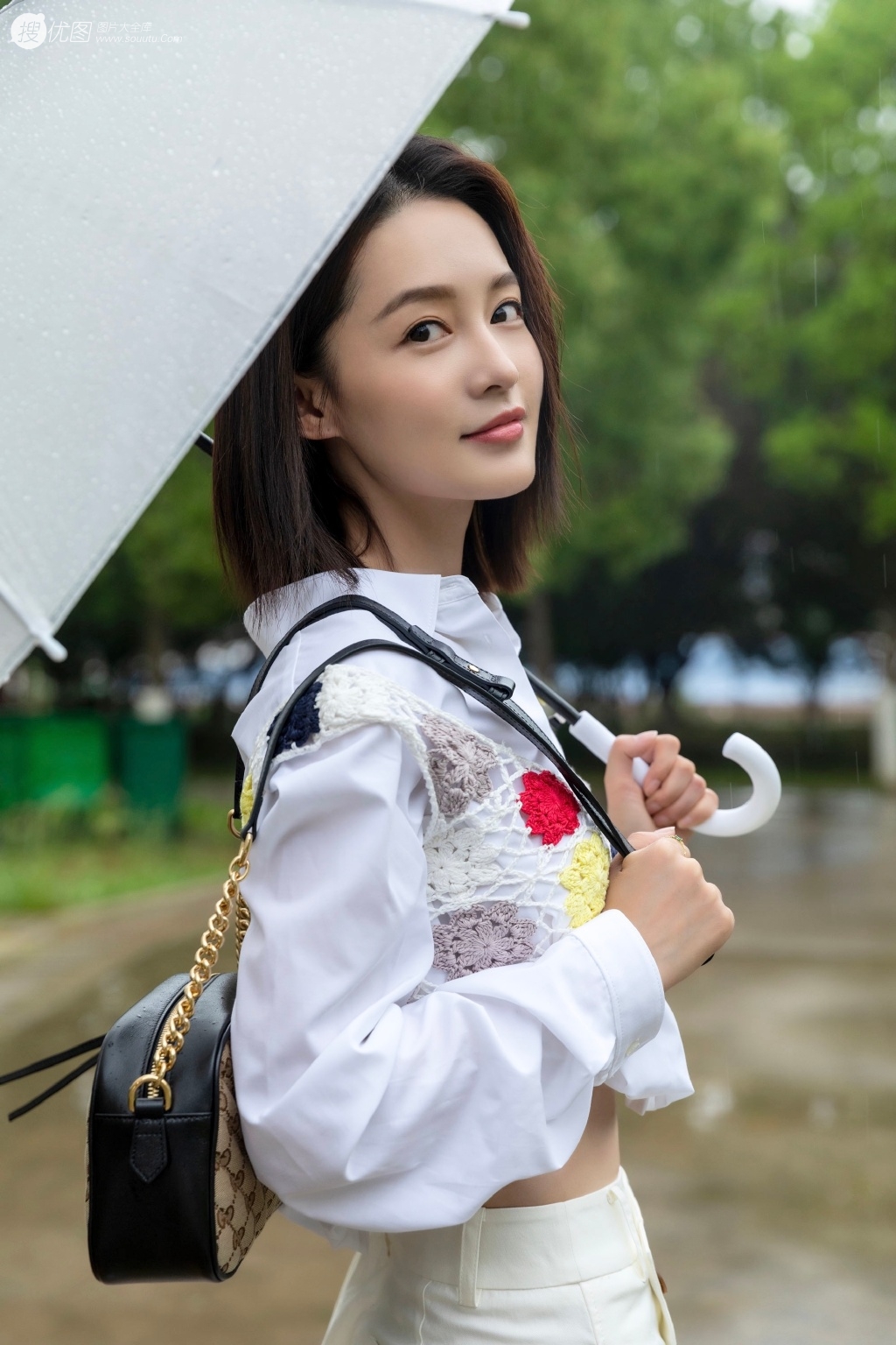 <span style='color:red;'>李沁</span>手拿雨伞雨天出街，白衣短裙气质清新