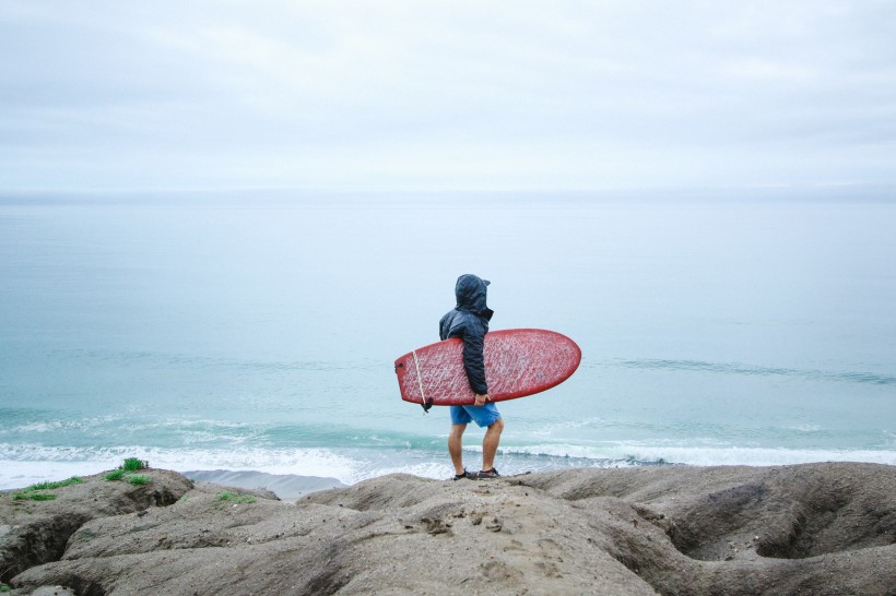 海边抱着冲浪板的欧美<span style='color:red;'>年轻人</span>唯美励志运动图片