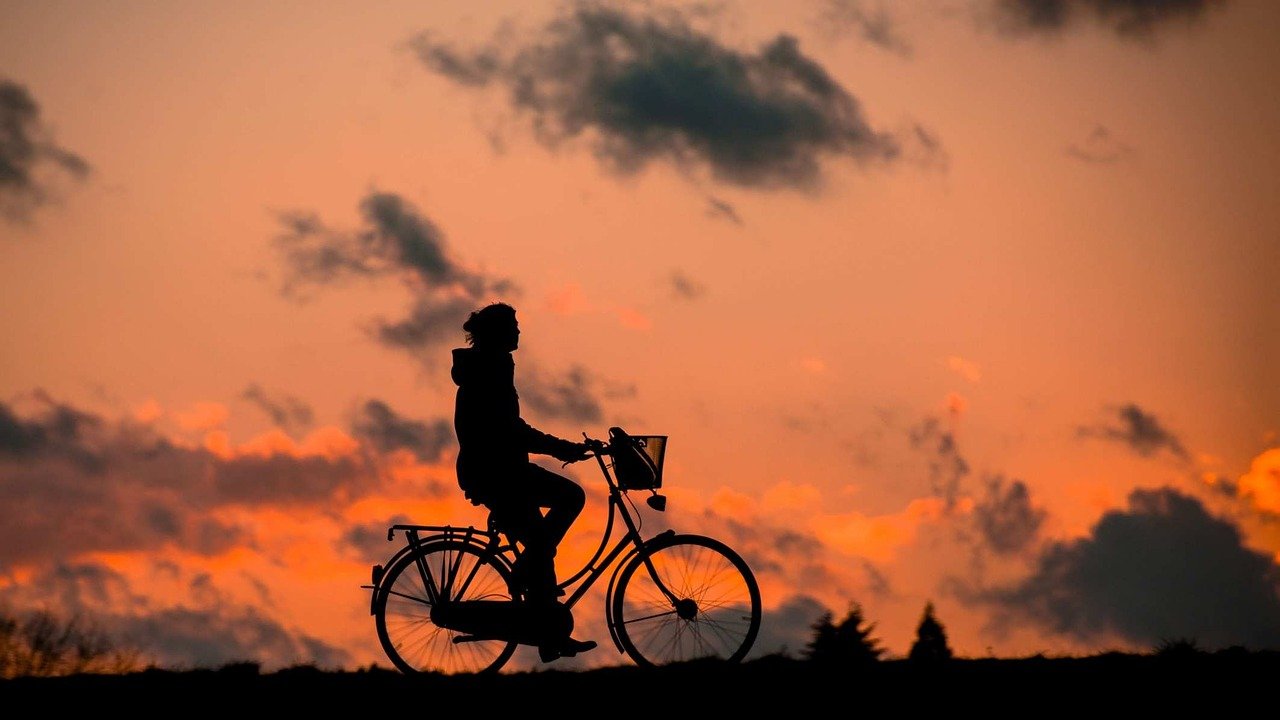 骑<span style='color:red;'>自行车</span>行走在唯美黄昏下的年轻男男女女意境图片