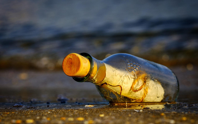 漂流瓶图片，<span style='color:red;'>海边</span>沙滩上的漂流瓶唯美背景图片